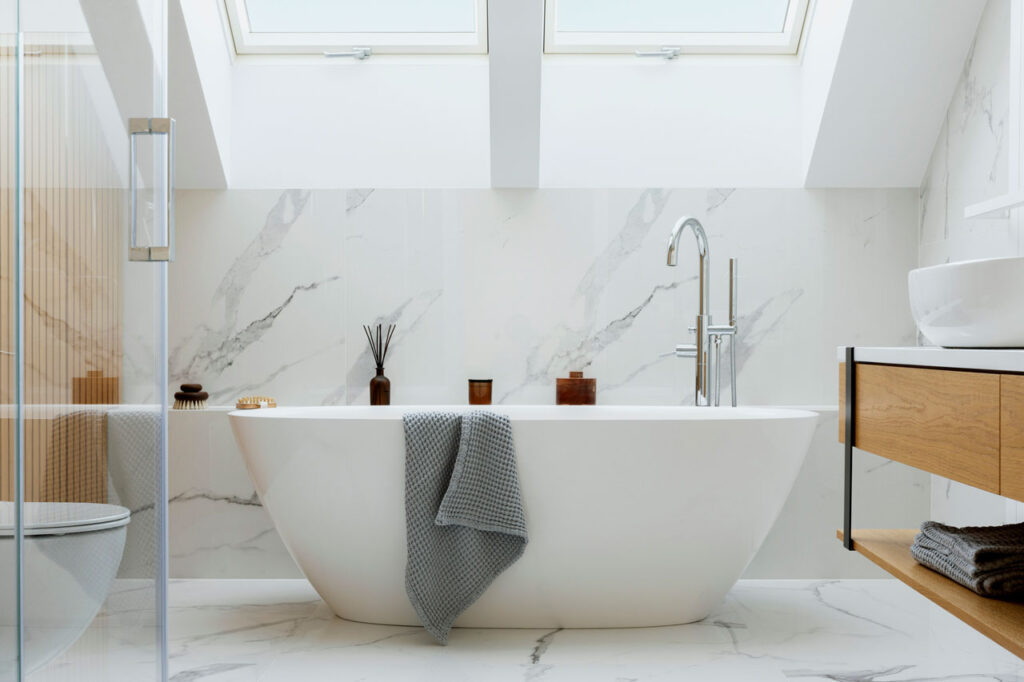 Modern bathroom remodel with marble walls and freestanding tub in Bend, OR